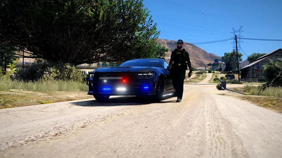 Deputy walking from a slicktop Charger on a dirt road